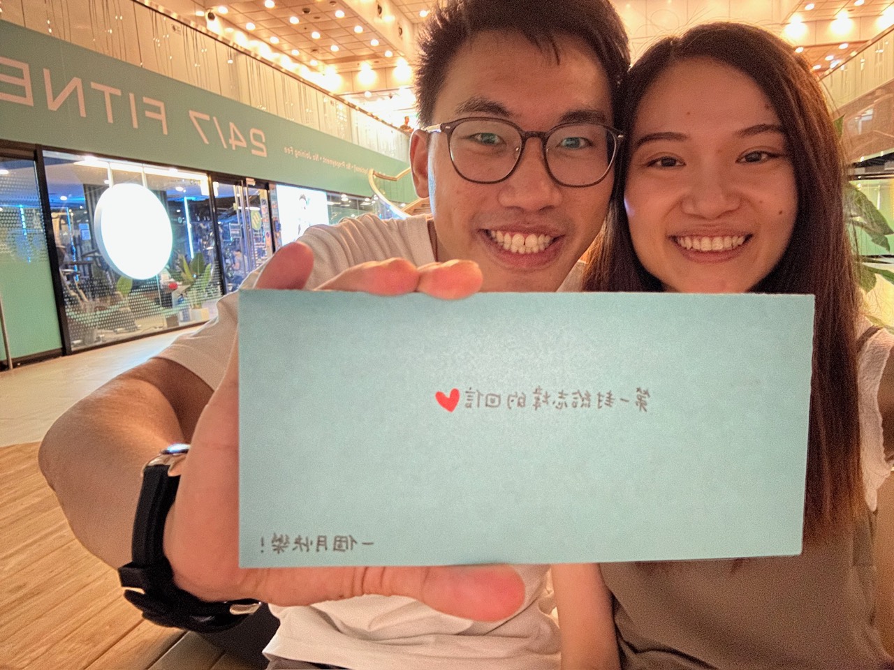 志煒和慧欣拿著一張小卡合照