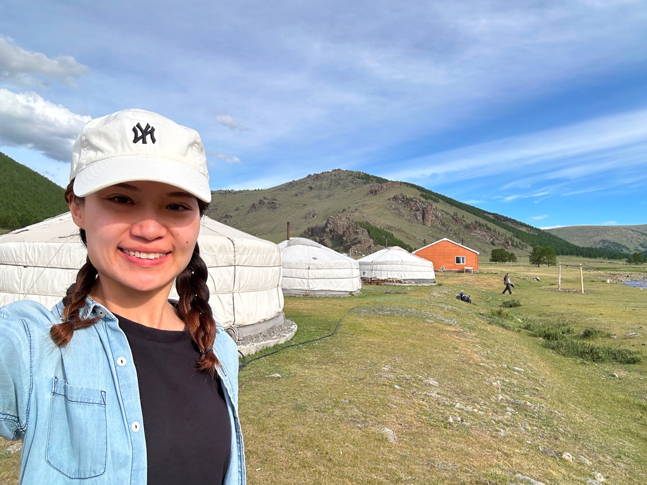 慧欣戴住白色帽、梳住孖辮，喺草地上微笑影相